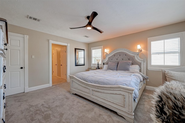 bedroom with light colored carpet, a textured ceiling, and ceiling fan