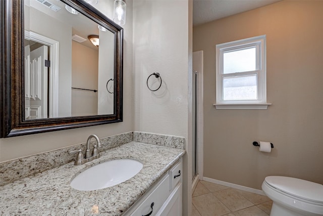 bathroom featuring visible vents, toilet, vanity, baseboards, and tile patterned floors