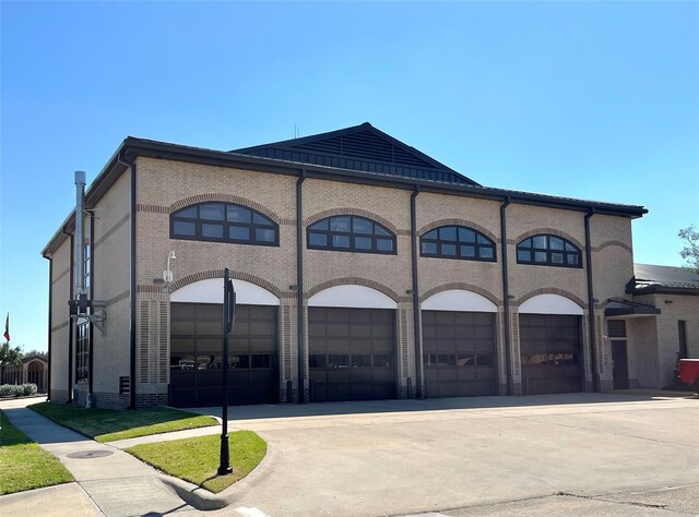 view of front of home featuring a garage, driveway, and brick siding