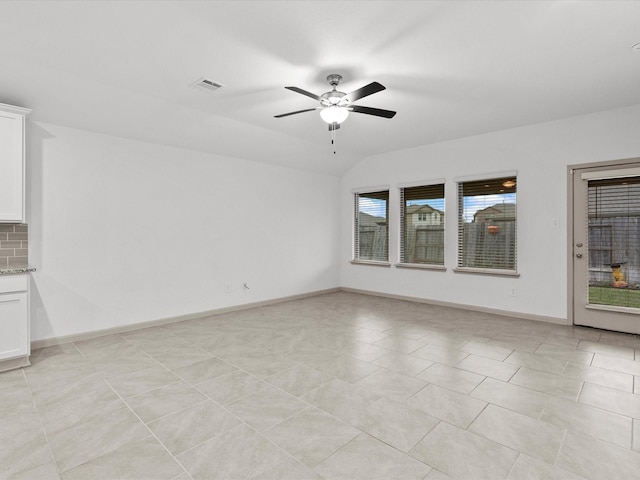 spare room with light tile patterned floors, vaulted ceiling, and ceiling fan