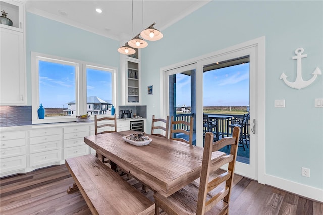 dining space featuring crown molding, dark wood-type flooring, wine cooler, and built in features