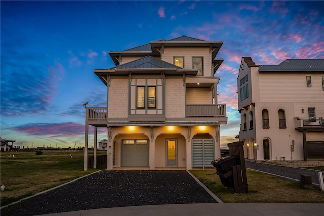 view of front of property with a garage, a lawn, and a balcony