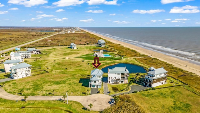 birds eye view of property featuring a water view and a beach view