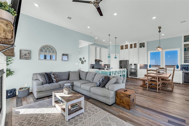 living room featuring wine cooler, ceiling fan, and light wood-type flooring