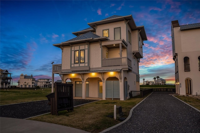 view of front of house with a yard and a balcony