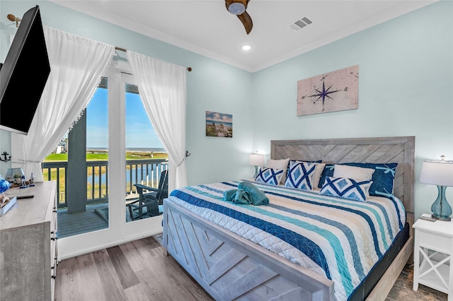 bedroom with wood-type flooring, access to exterior, ceiling fan, crown molding, and a water view