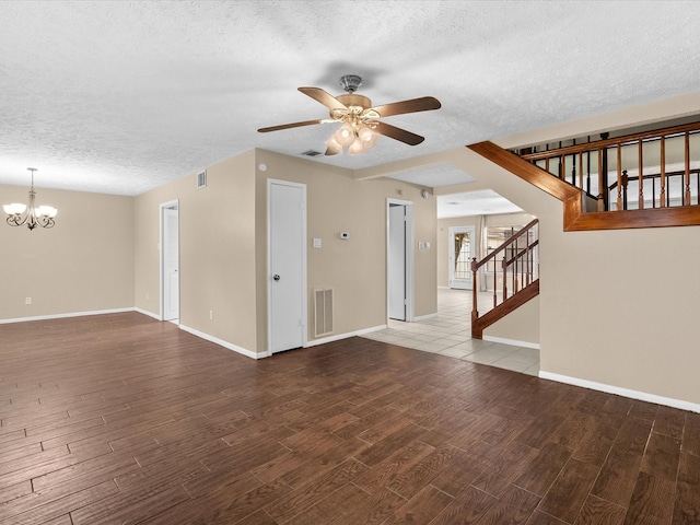 unfurnished living room featuring hardwood / wood-style flooring, ceiling fan with notable chandelier, and a textured ceiling