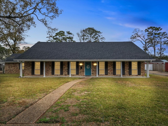 single story home with a lawn and covered porch