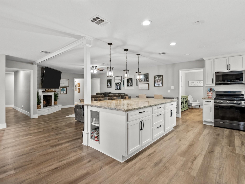 kitchen with a kitchen island, white cabinets, and appliances with stainless steel finishes