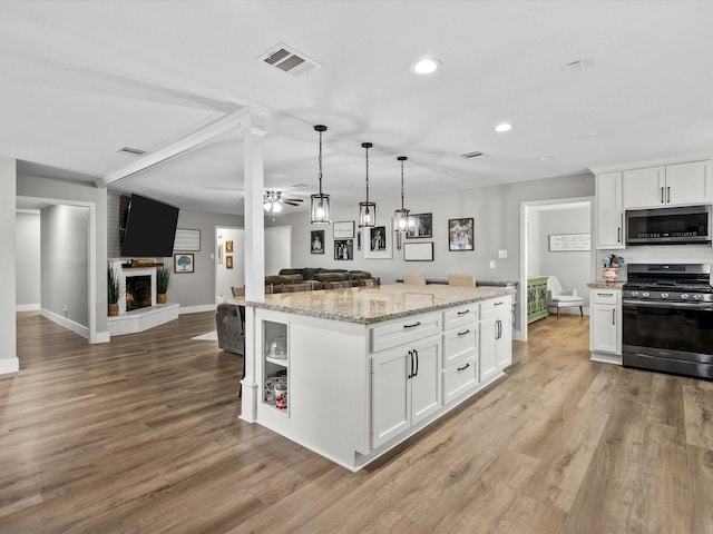 kitchen with a kitchen island, white cabinets, and appliances with stainless steel finishes