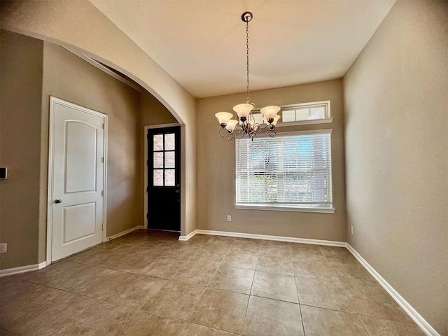 unfurnished dining area with a notable chandelier and tile patterned floors