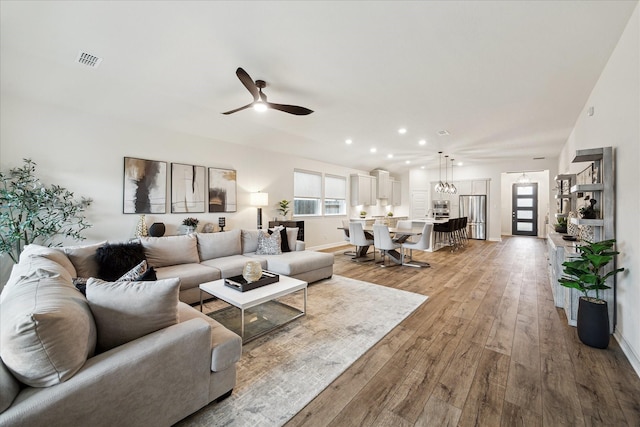 living room featuring light hardwood / wood-style floors and ceiling fan