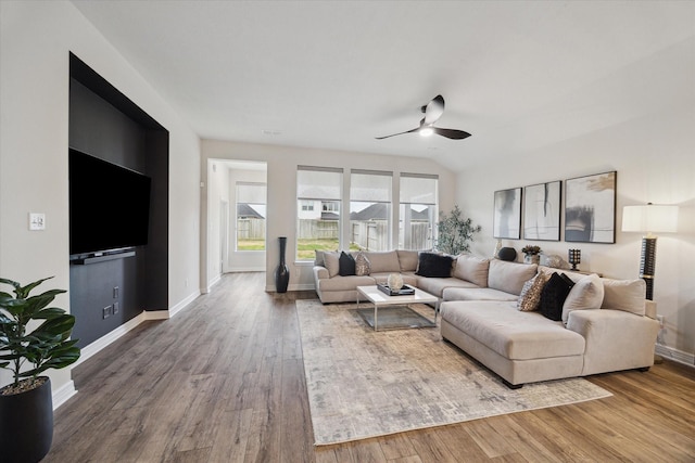 living room with wood-type flooring, ceiling fan, and vaulted ceiling