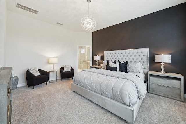 carpeted bedroom with connected bathroom and a notable chandelier