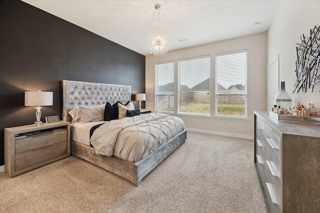 bedroom with a chandelier and light carpet