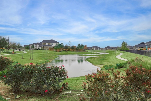 surrounding community with a water view and a yard