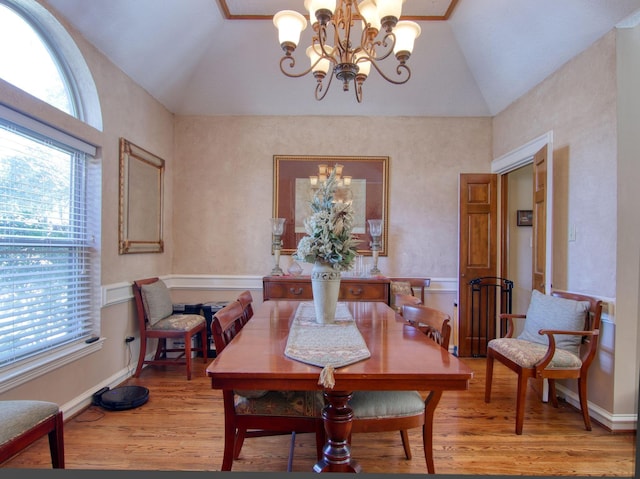 dining room featuring lofted ceiling, hardwood / wood-style floors, and an inviting chandelier