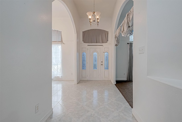 tiled entrance foyer with an inviting chandelier