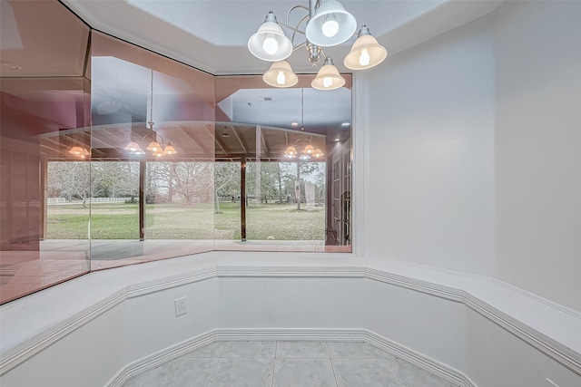 unfurnished dining area featuring tile patterned flooring, a wealth of natural light, and an inviting chandelier