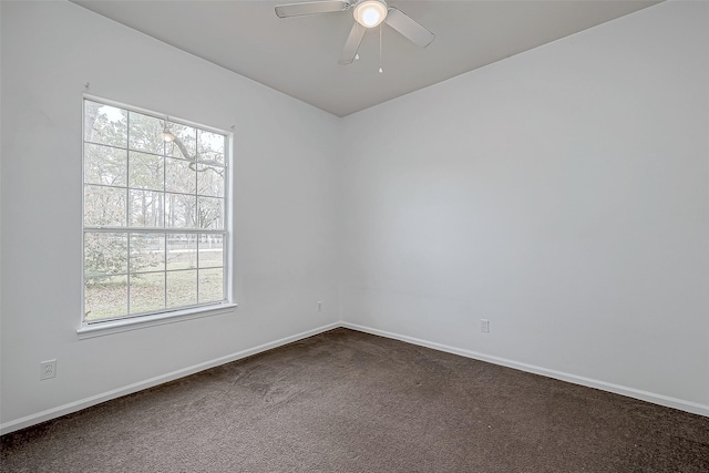 spare room with ceiling fan and dark carpet