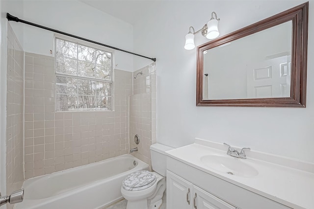 full bathroom with tiled shower / bath, vanity, and toilet