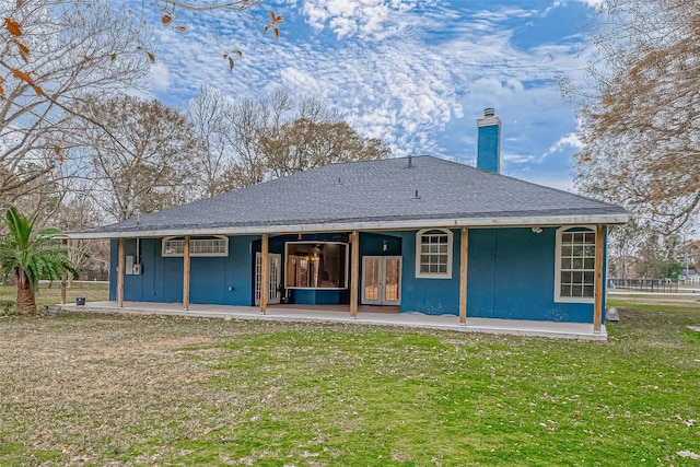 rear view of house with a patio area and a lawn