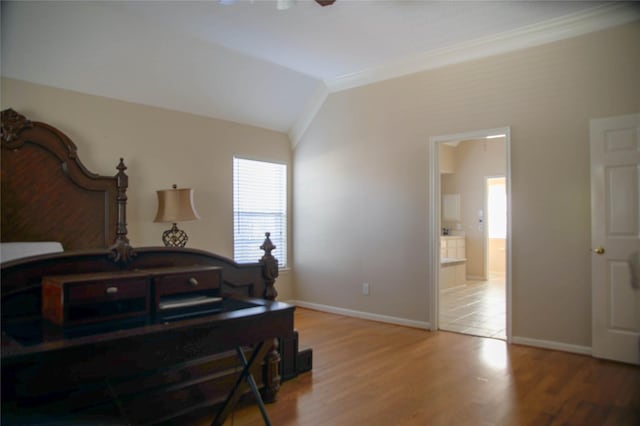 bedroom with lofted ceiling, wood-type flooring, connected bathroom, and ornamental molding