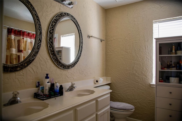 bathroom featuring vanity, toilet, and a wealth of natural light