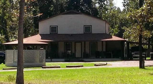 rear view of property with a lawn