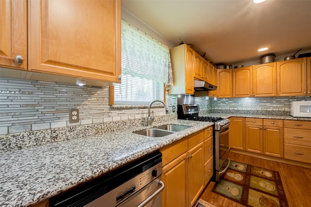 kitchen with stainless steel gas range oven, dishwashing machine, white microwave, under cabinet range hood, and a sink