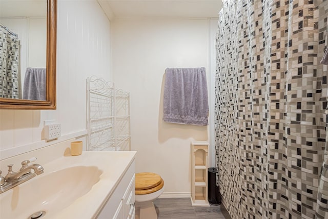 bathroom with toilet, a shower with curtain, wood finished floors, and vanity