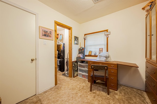 office area with a textured ceiling and light colored carpet