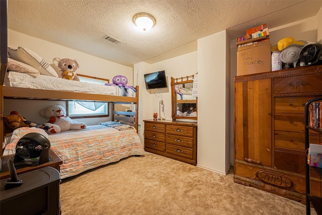 carpeted bedroom with a textured ceiling and visible vents