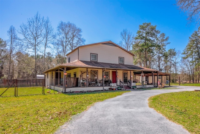 farmhouse featuring a gate, covered porch, a front lawn, and fence