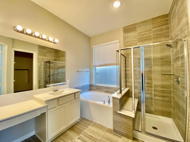 bathroom featuring plus walk in shower, vanity, and tile patterned floors