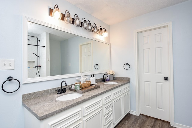 bathroom featuring vanity, wood-type flooring, and a textured ceiling