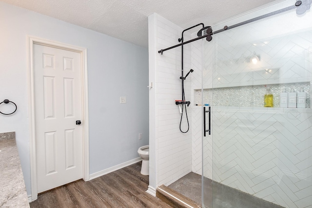 bathroom featuring hardwood / wood-style flooring, walk in shower, a textured ceiling, and toilet