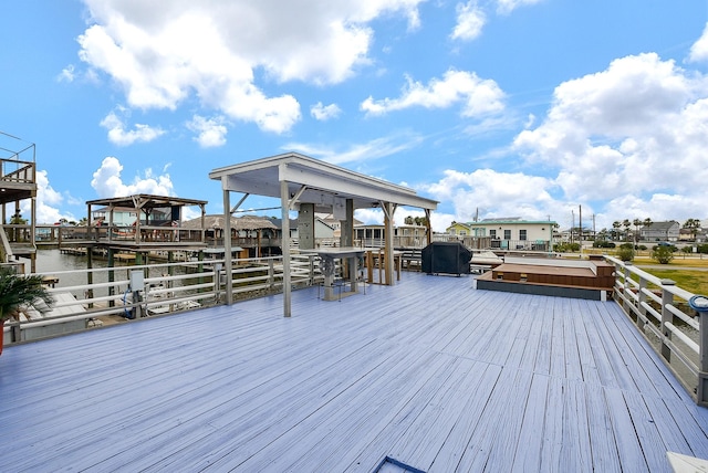 deck with a hot tub and a water view