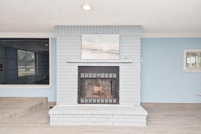 room details featuring hardwood / wood-style flooring, a fireplace, and a textured ceiling