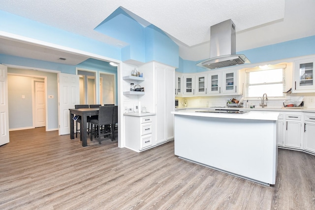 kitchen with white cabinetry, backsplash, a center island, island range hood, and a textured ceiling