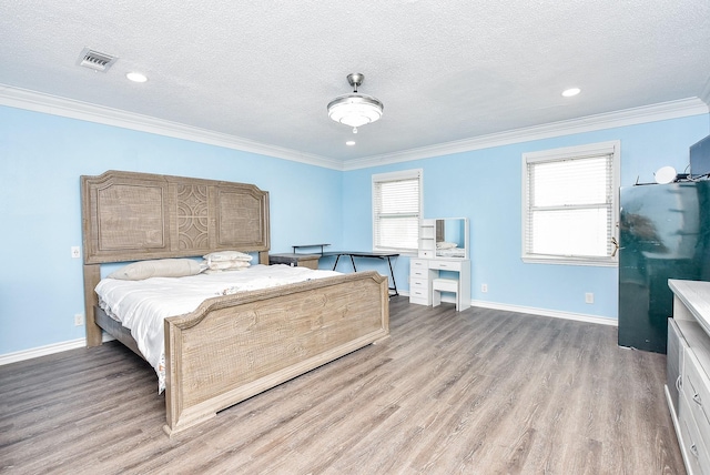 bedroom featuring ornamental molding, black fridge, a textured ceiling, and light hardwood / wood-style floors