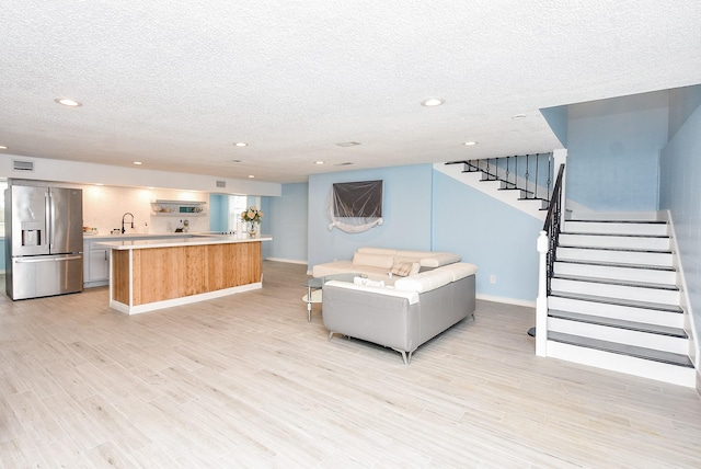 living room with light hardwood / wood-style flooring and a textured ceiling