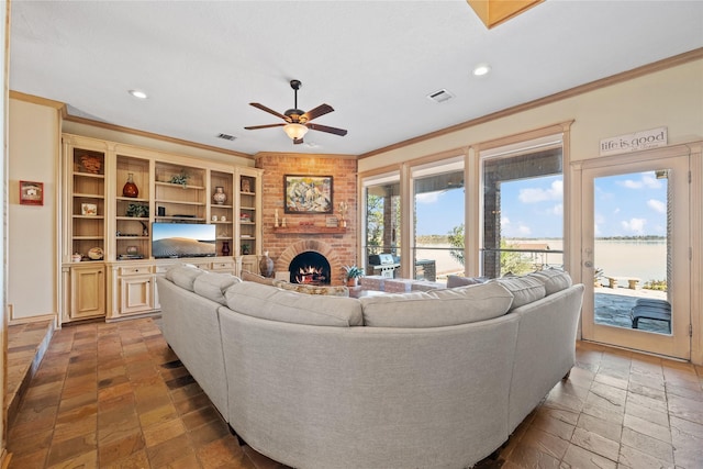 living room featuring ornamental molding, a brick fireplace, and ceiling fan