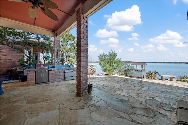 view of patio featuring a water view, an outdoor kitchen, and ceiling fan