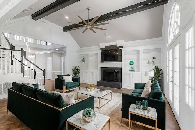 living room with beam ceiling, ornamental molding, a healthy amount of sunlight, and a fireplace