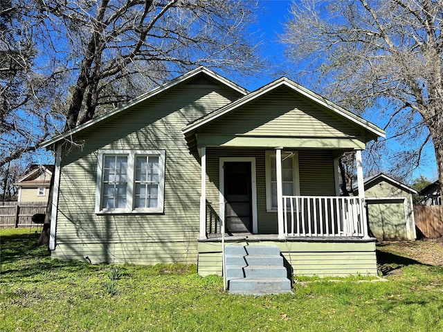 bungalow-style house featuring a shed, a front yard, and covered porch