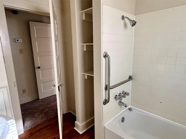 bathroom with hardwood / wood-style flooring and bathtub / shower combination