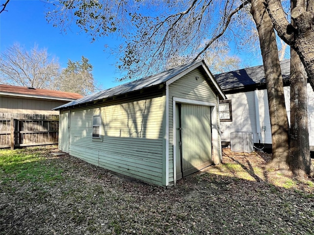 view of side of home featuring a garage, an outdoor structure, and central AC unit