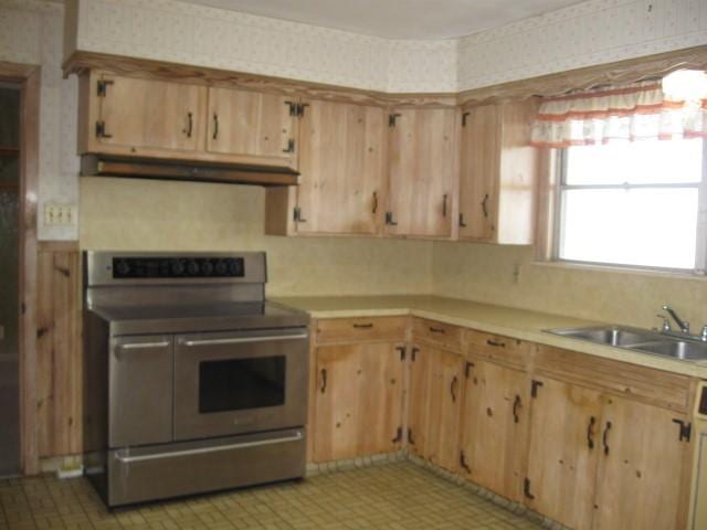 kitchen featuring double oven range, sink, and extractor fan