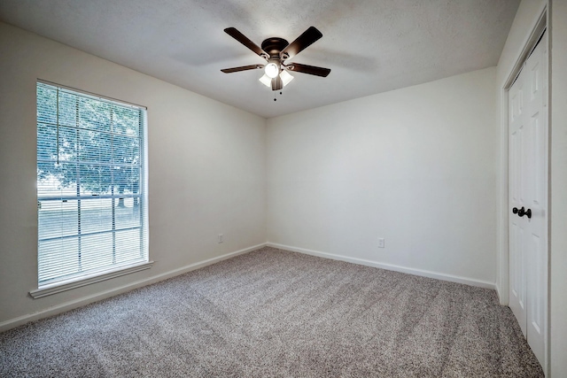 spare room featuring carpet and ceiling fan